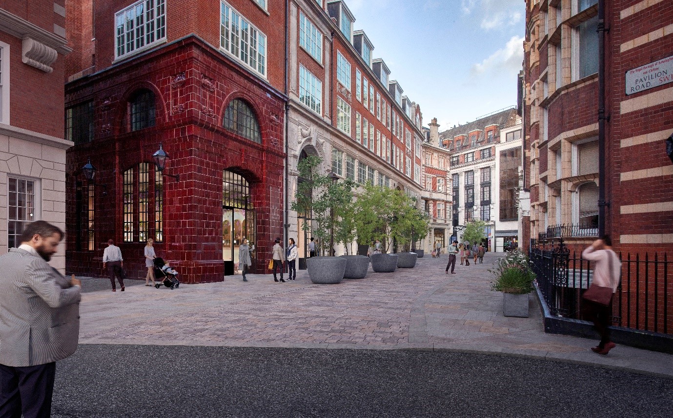A computer generated visual of the proposals for Basil Street from the Pavilion Road end. The footway has new natural stone paving.  To the centre of the street are new trees in large round pots.  CGI people are dotted throughout the street, enjoying the new streetscape.–