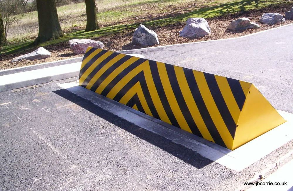 This is a photo of metal wedge barriers raised from the road surface to stop cars.